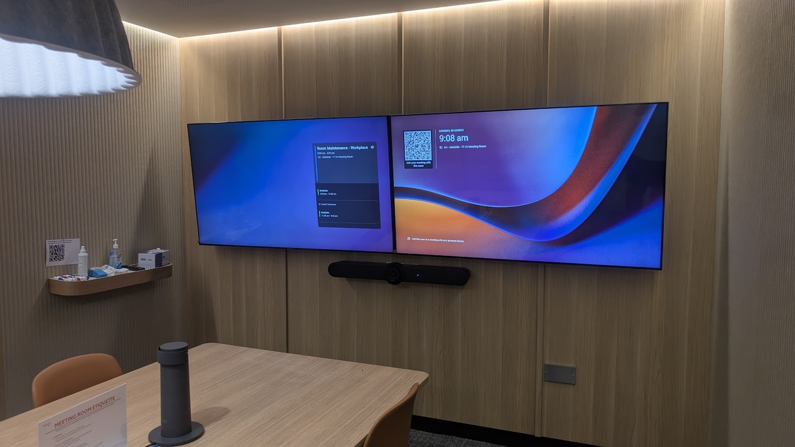 Boardroom with dual commercial displays and integrated conferencing equipment