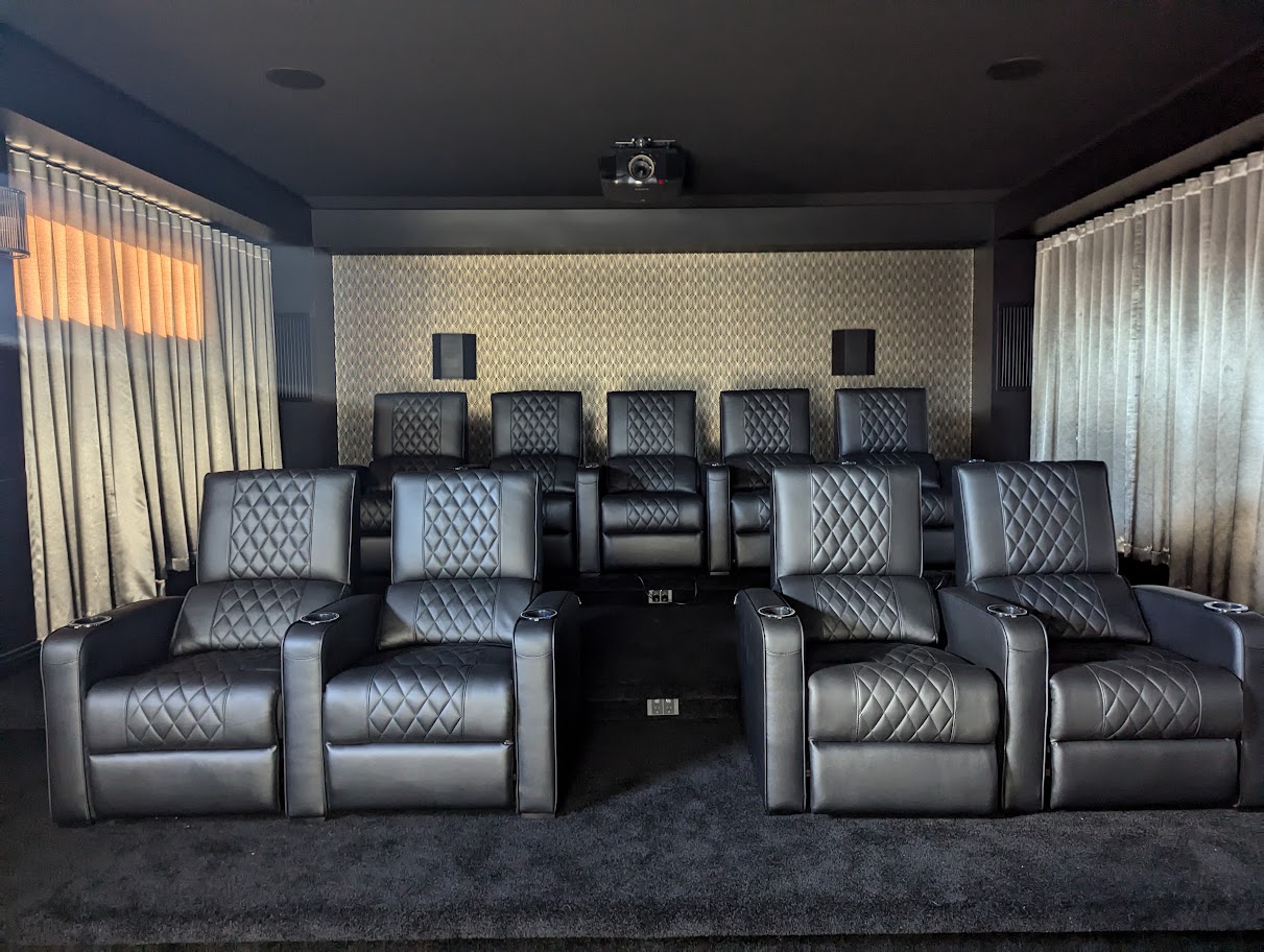 Dedicated cinema room with multiple rows of leather recliner seating